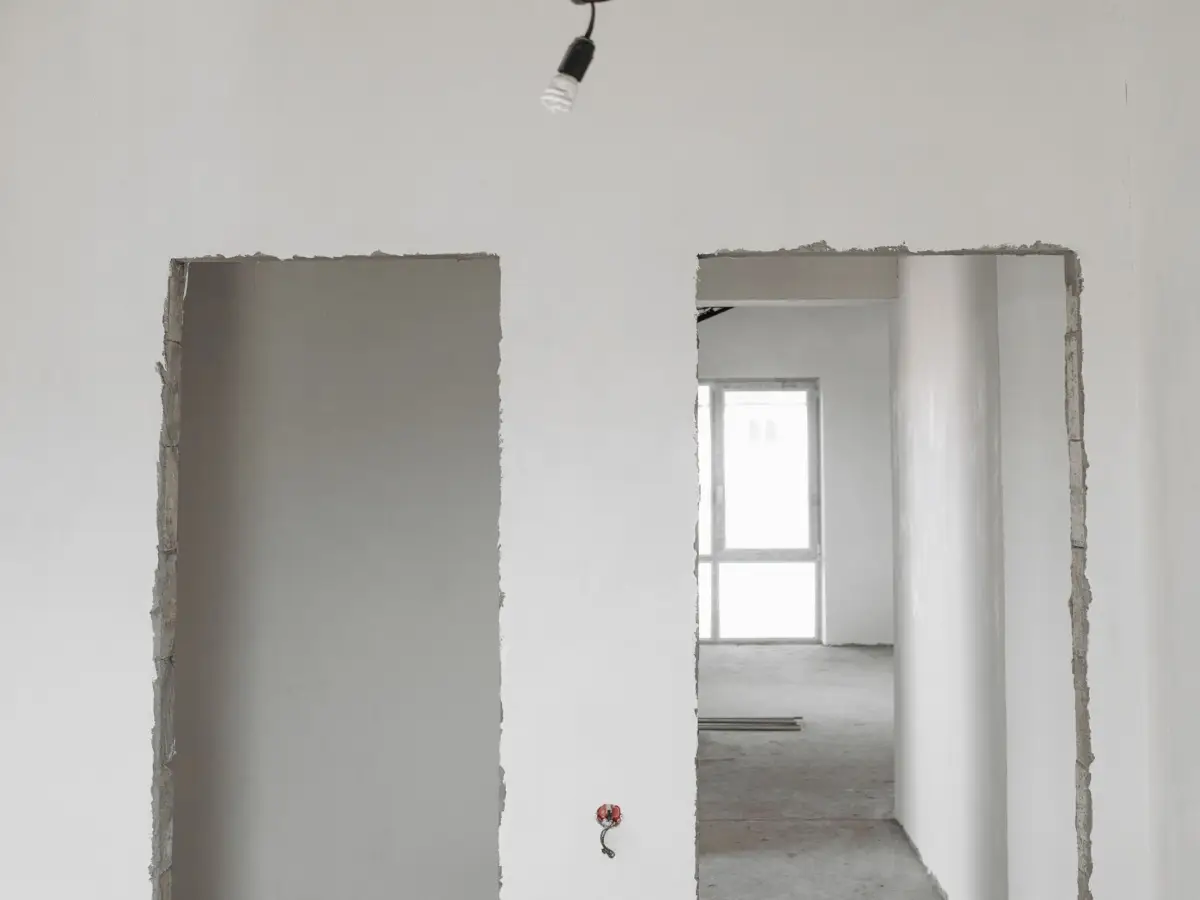 Unfinished apartment interior with plastered walls and construction dust before cleaning